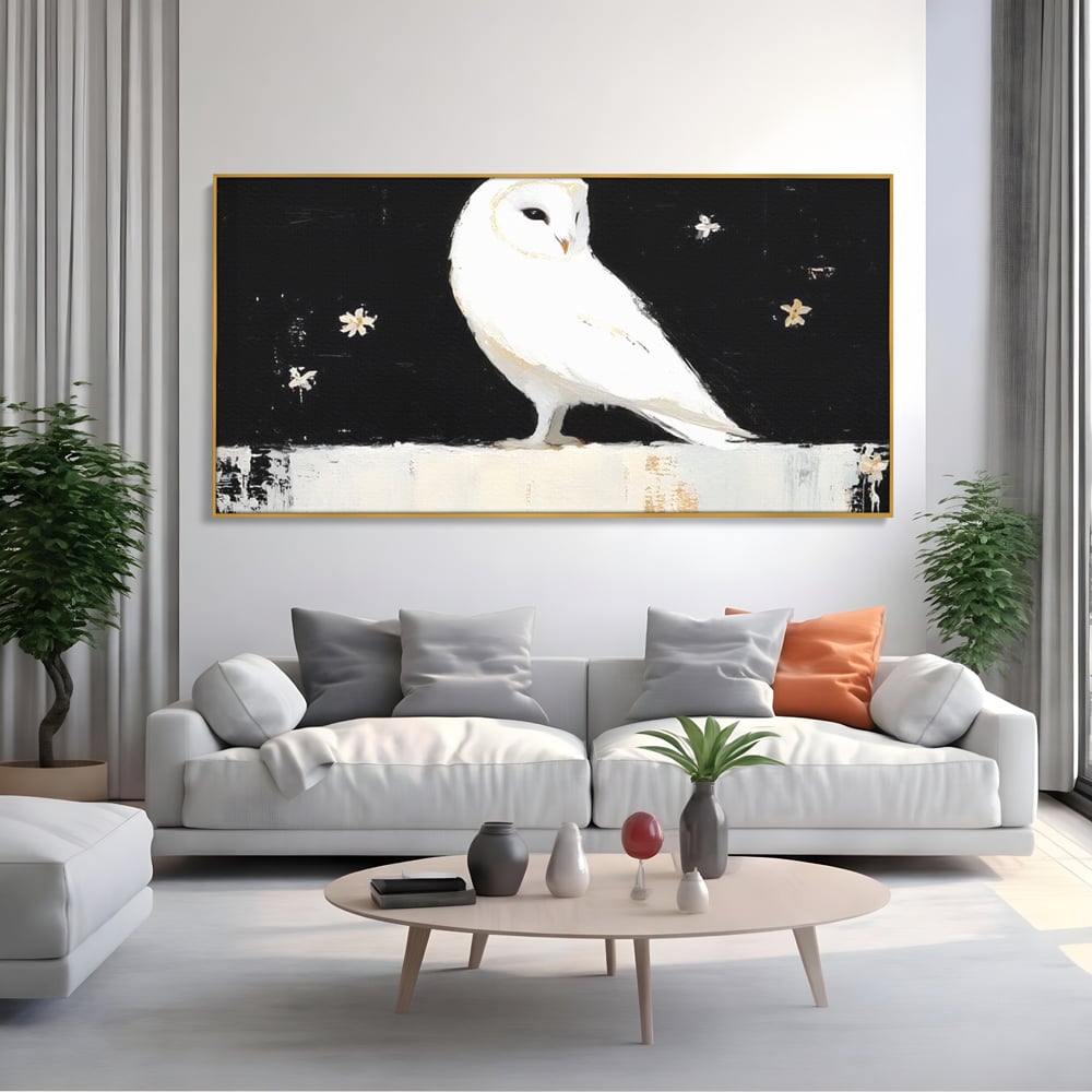 Tablou canvas cu tablou canvas cu bufnita alba, in rama de aluminiu auriu, pe perete intr-un living